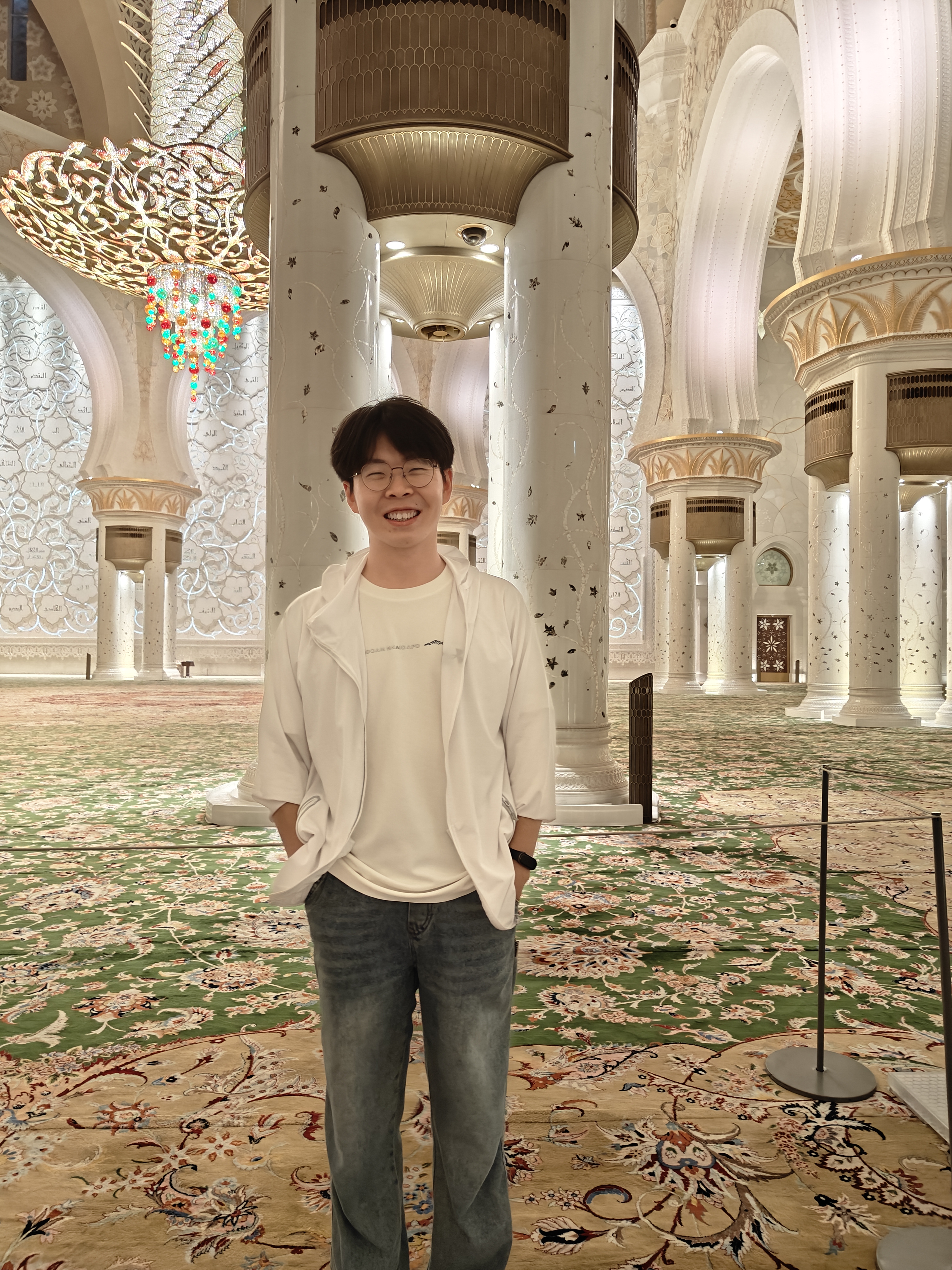 Zengzhi Wang smiling in an ornate interior in the UAE.